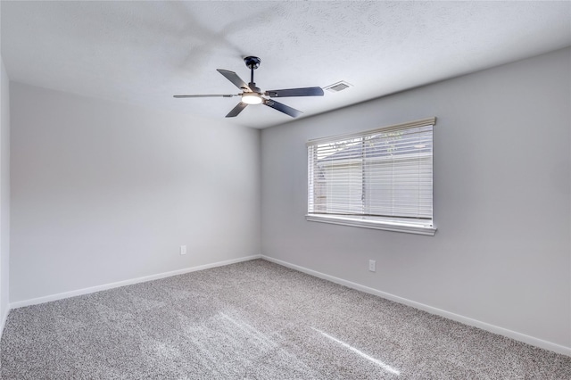 carpeted spare room with a textured ceiling, ceiling fan, visible vents, and baseboards