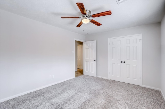 unfurnished bedroom featuring carpet floors, a closet, ceiling fan, and baseboards