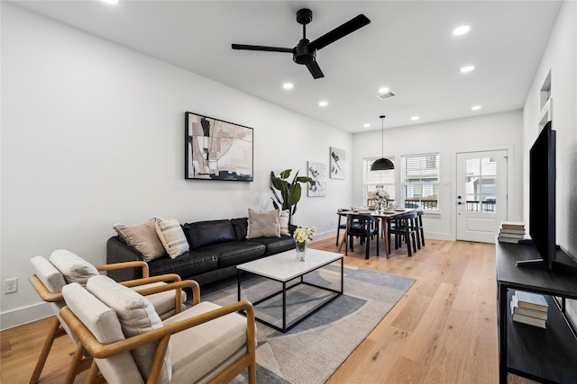 living room featuring light wood-style floors, recessed lighting, visible vents, and baseboards