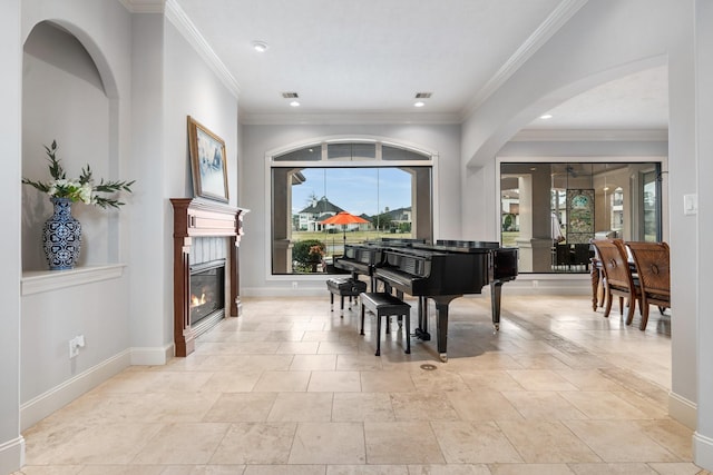 sitting room featuring ornamental molding, a glass covered fireplace, visible vents, and baseboards