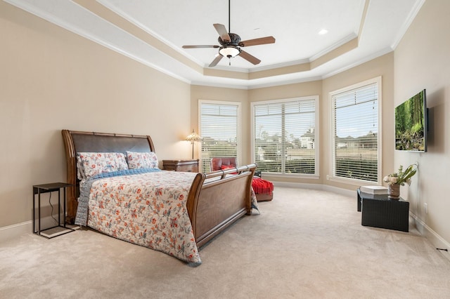 bedroom featuring baseboards, a raised ceiling, a ceiling fan, carpet, and crown molding