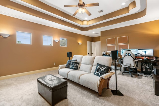 carpeted living room with visible vents, a tray ceiling, a ceiling fan, and baseboards