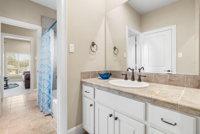 bathroom with shower / bath combo, tile patterned flooring, vanity, and baseboards