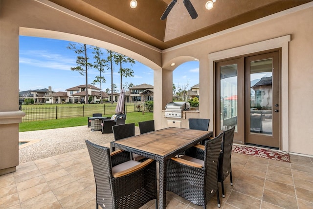 view of patio with outdoor dining space, grilling area, fence, and a residential view