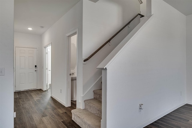 foyer featuring dark wood-type flooring, baseboards, and stairs