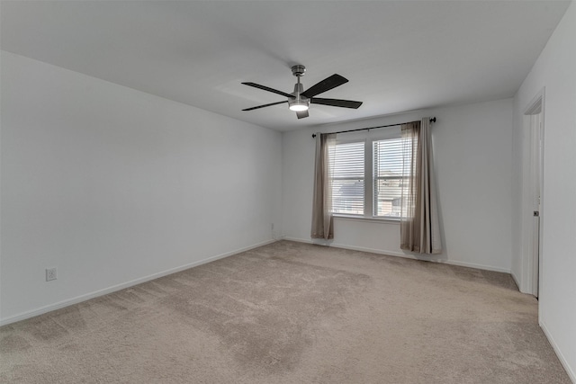 unfurnished room featuring a ceiling fan, light carpet, and baseboards