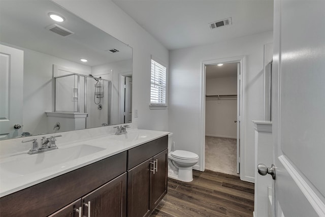 full bath featuring a walk in closet, visible vents, a sink, and a shower stall