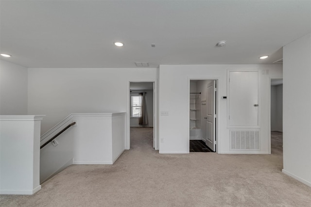 spare room featuring light carpet, visible vents, baseboards, and recessed lighting