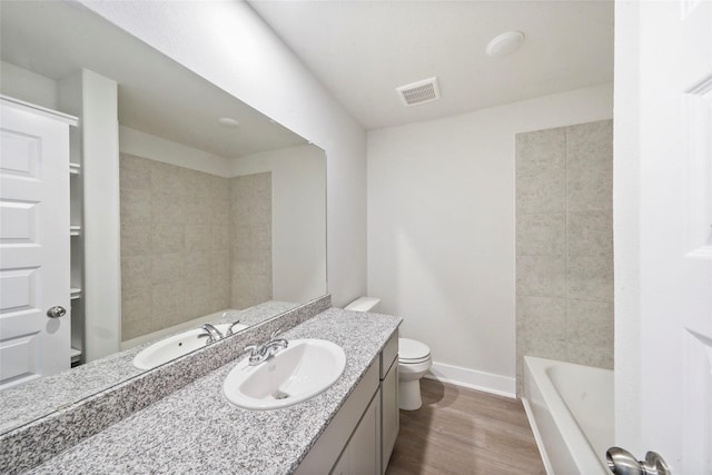 full bathroom with baseboards, visible vents, wood finished floors, vanity, and a bath