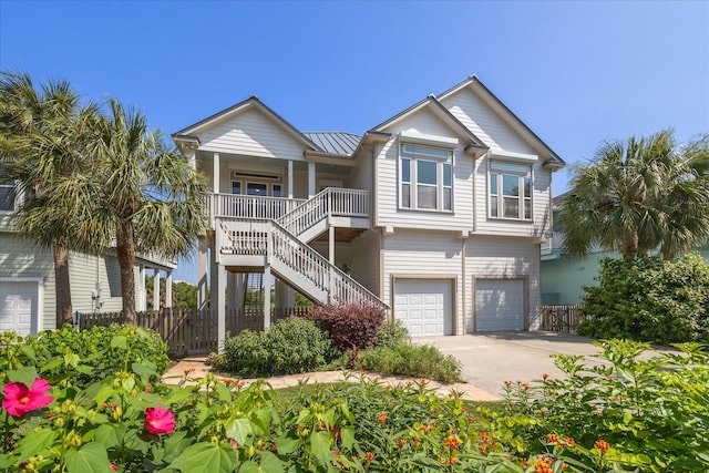 view of front of property featuring metal roof, covered porch, driveway, stairway, and a standing seam roof