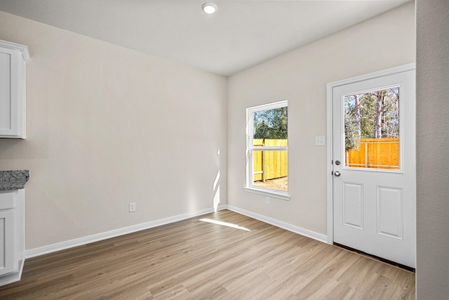 foyer entrance featuring light wood-type flooring and baseboards