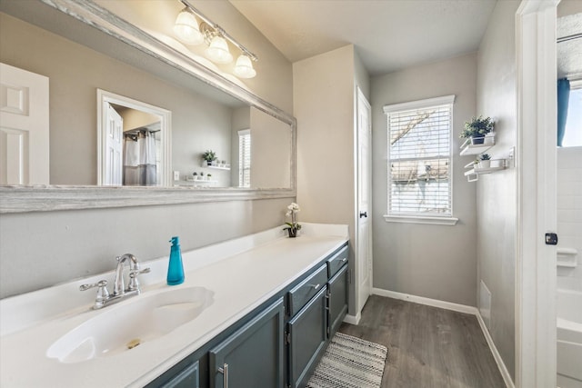 bathroom featuring shower / tub combo, wood finished floors, vanity, and baseboards