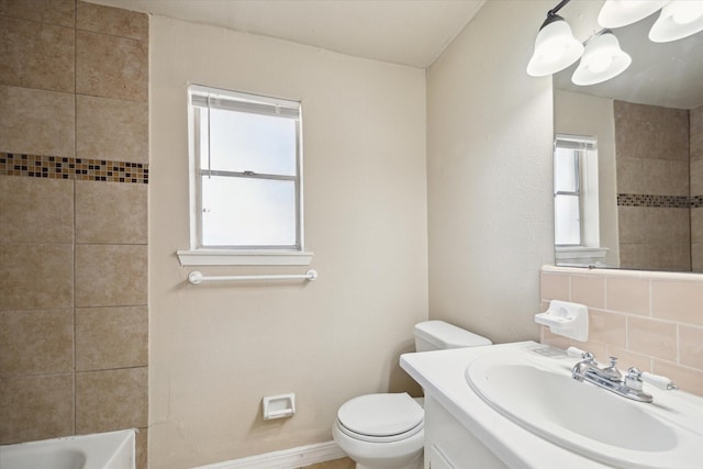 bathroom featuring toilet, vanity, and baseboards