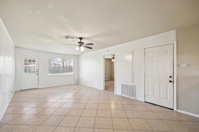 interior space with light tile patterned floors, visible vents, baseboards, and ceiling fan