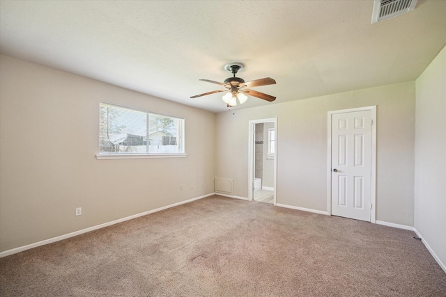 unfurnished bedroom featuring baseboards, visible vents, carpet floors, and connected bathroom