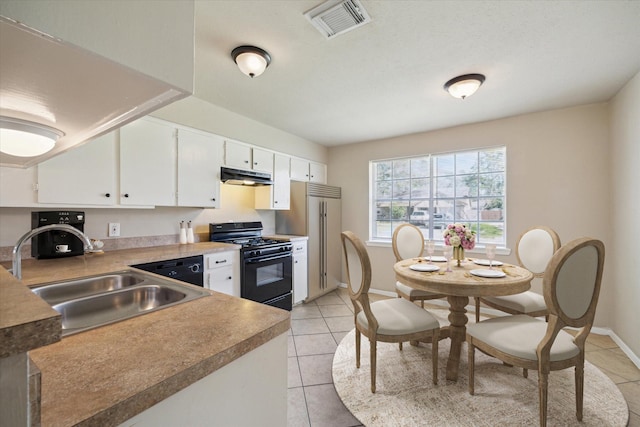 kitchen featuring light tile patterned floors, visible vents, a sink, under cabinet range hood, and black range with gas stovetop