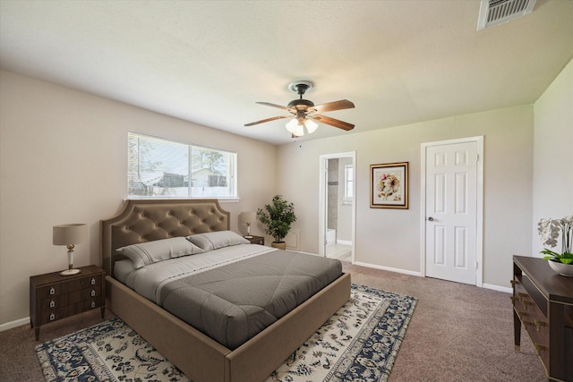 bedroom with visible vents, baseboards, ceiling fan, carpet flooring, and ensuite bath