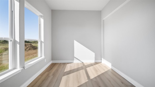 unfurnished room with light wood-style floors and baseboards