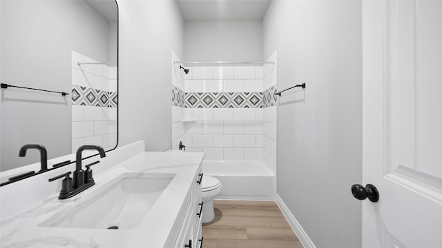 full bathroom with shower / bathing tub combination, toilet, vanity, wood finished floors, and baseboards