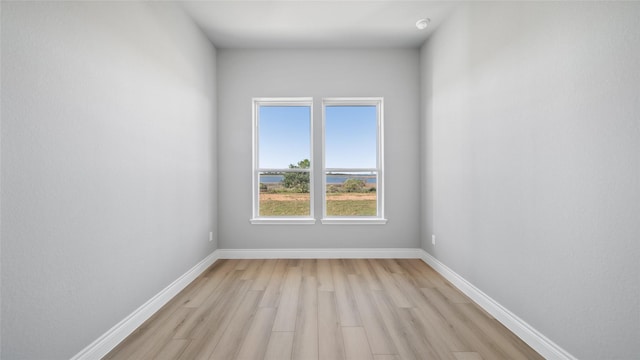 empty room with light wood-style flooring and baseboards