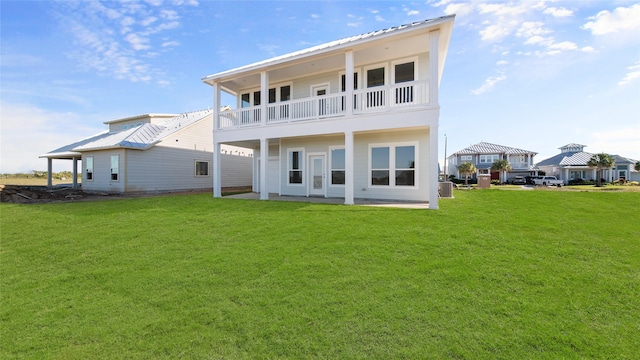 back of house featuring metal roof, a lawn, a balcony, and a gazebo