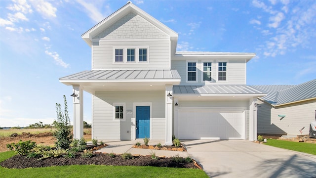 view of front of house featuring a garage, concrete driveway, a standing seam roof, and metal roof