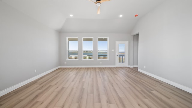 unfurnished living room featuring vaulted ceiling, baseboards, and light wood-style floors