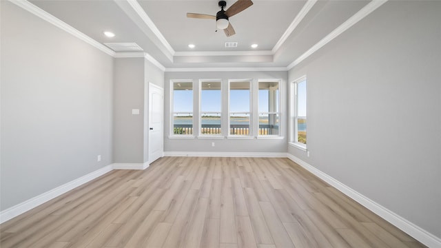 empty room with light wood-type flooring, a ceiling fan, baseboards, and crown molding