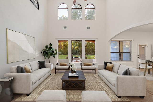 living room featuring visible vents, a high ceiling, and arched walkways