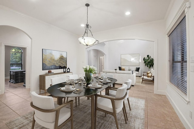 dining room featuring light tile patterned floors, arched walkways, and ornamental molding