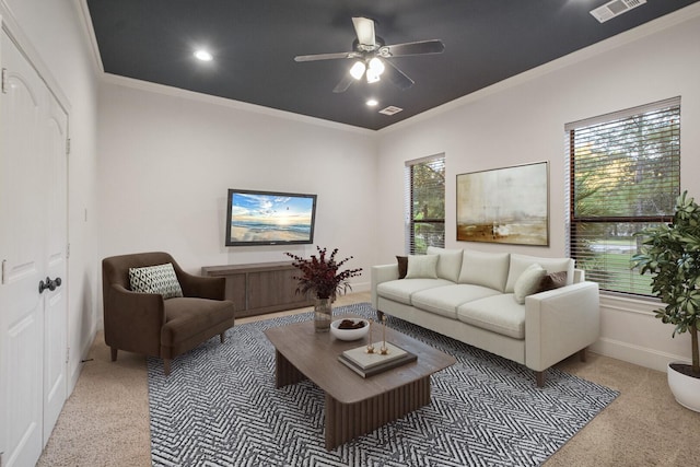 living area with carpet floors, a ceiling fan, visible vents, and crown molding