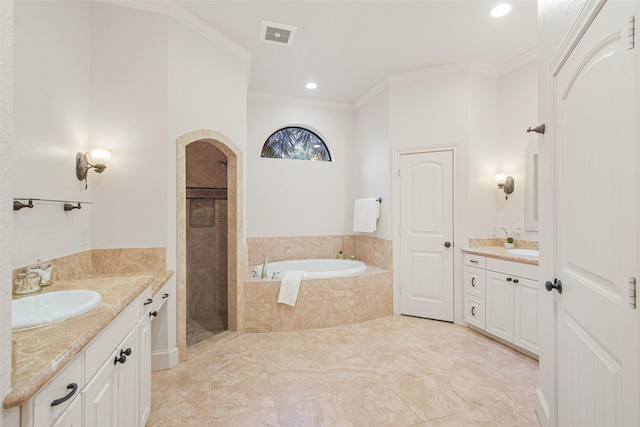 full bath with a garden tub, crown molding, two vanities, visible vents, and a sink