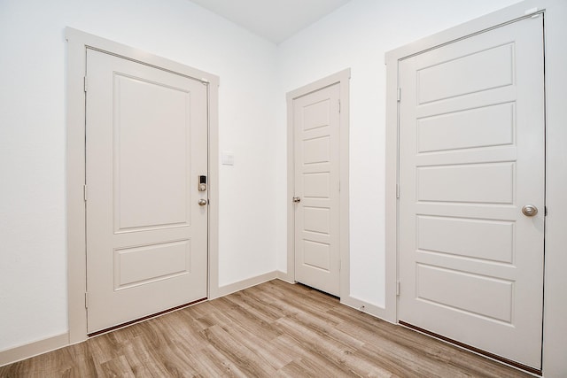 foyer featuring baseboards and light wood finished floors