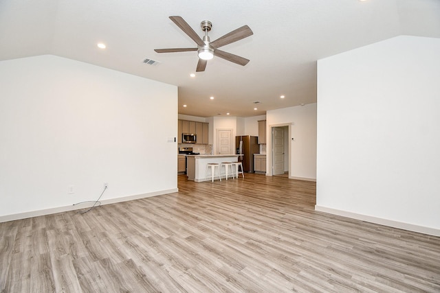 unfurnished living room featuring lofted ceiling, ceiling fan, light wood-style flooring, and baseboards