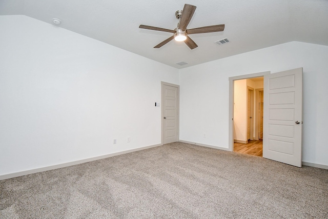 unfurnished room featuring light colored carpet, visible vents, a ceiling fan, vaulted ceiling, and baseboards