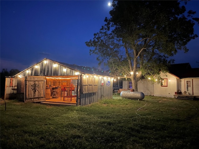 back of house at night with a yard