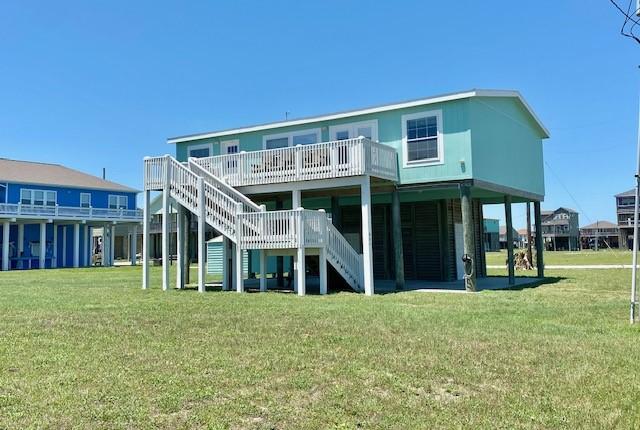 back of house featuring a deck, a yard, and stairs