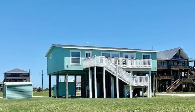 rear view of property with a wooden deck, stairway, and a yard