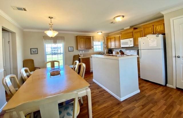 dining space with dark wood finished floors, visible vents, and crown molding