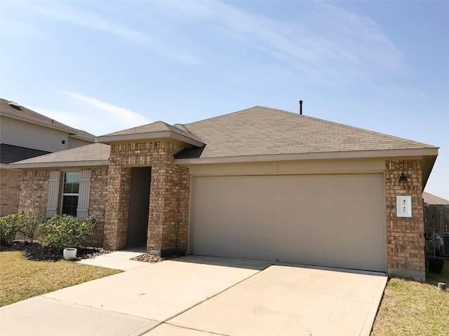 view of front of house with a garage, a shingled roof, concrete driveway, and brick siding