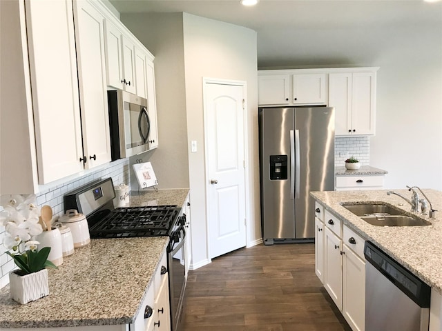 kitchen featuring appliances with stainless steel finishes, white cabinetry, a sink, and dark wood-style floors