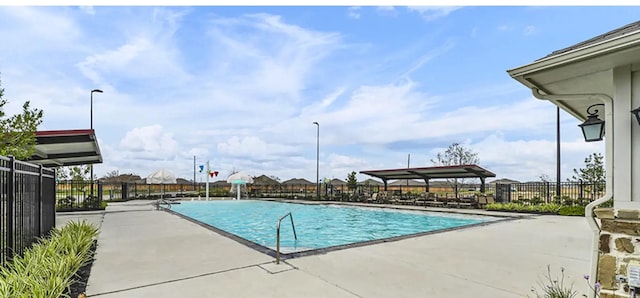 community pool featuring fence and a patio