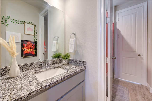 bathroom featuring a textured wall and vanity