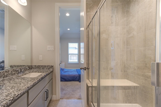 bathroom with a stall shower, tile patterned flooring, vanity, and ensuite bath