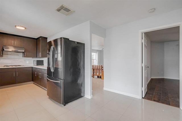 kitchen featuring visible vents, appliances with stainless steel finishes, light countertops, dark brown cabinets, and under cabinet range hood