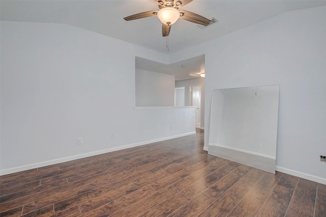 spare room with ceiling fan, vaulted ceiling, dark wood finished floors, and baseboards