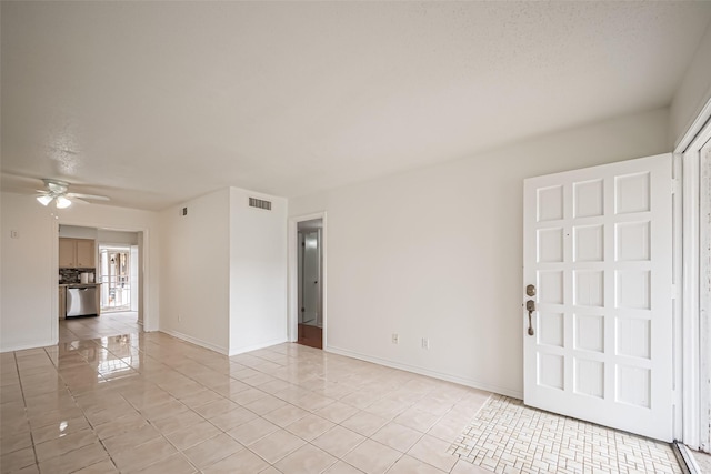 empty room with light tile patterned floors, baseboards, visible vents, and a ceiling fan