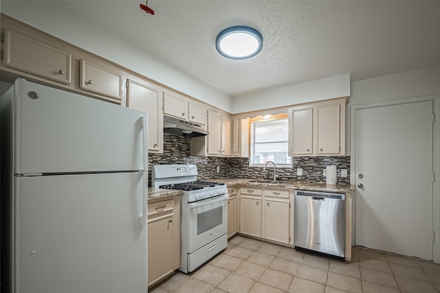 kitchen with white appliances, tasteful backsplash, light tile patterned floors, under cabinet range hood, and a sink