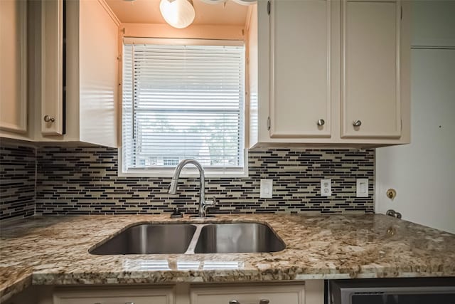 kitchen featuring beverage cooler, white cabinets, decorative backsplash, light stone counters, and a sink