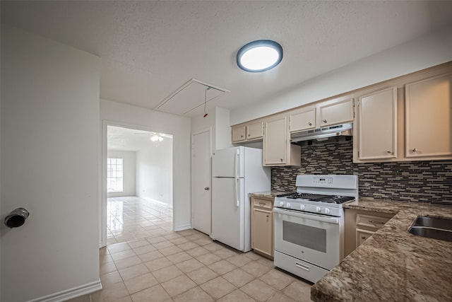 kitchen featuring decorative backsplash, light tile patterned flooring, a textured ceiling, white appliances, and under cabinet range hood